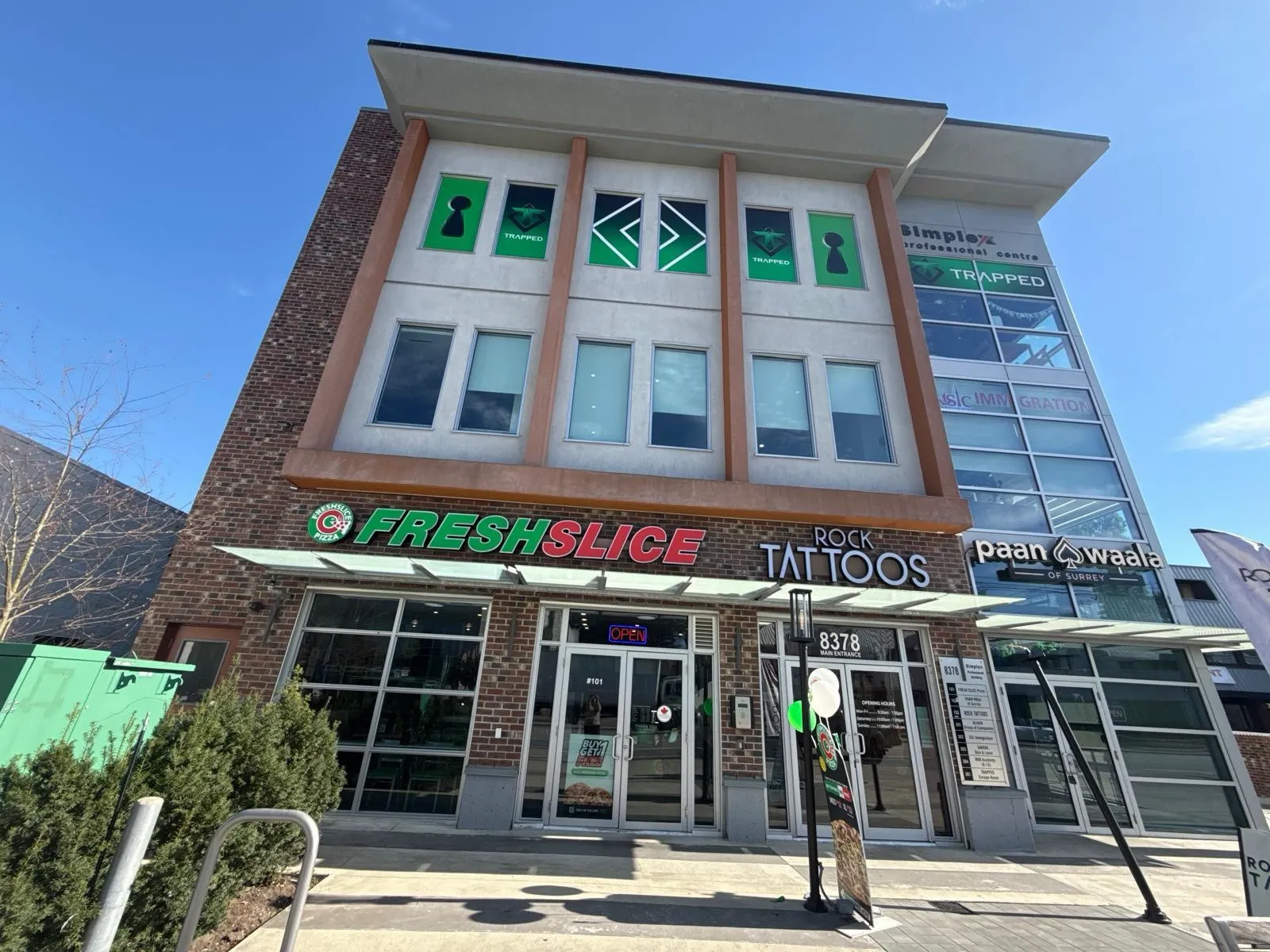 The front of 8378 120 Street in Surrey, the Simplex Professional Centre, with the main entrance marked 8378 between the ground floor shops