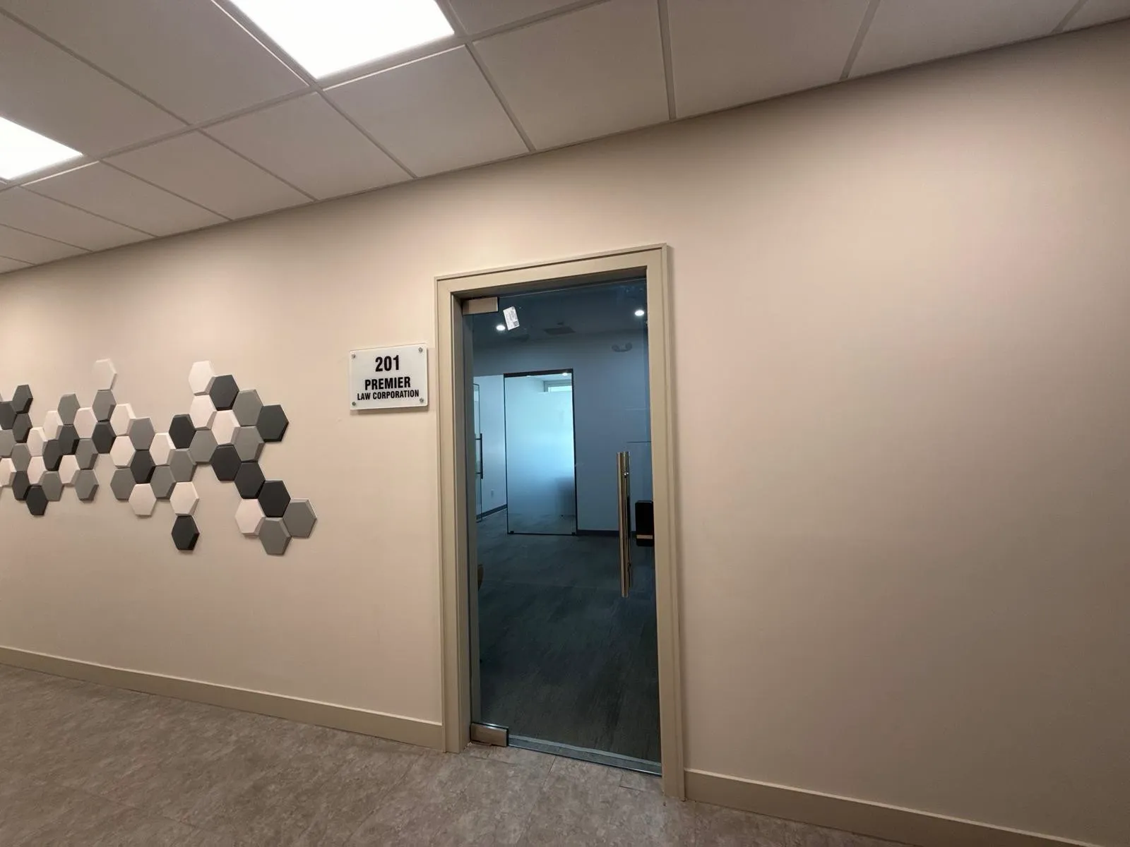 The glass door to Suite 201 on the second floor, with a sign reading 201 Premier Law Corporation